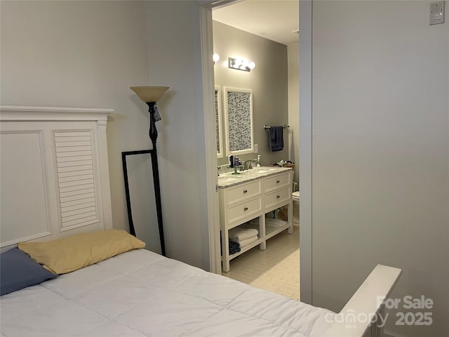 bedroom featuring a sink, brick floor, and connected bathroom