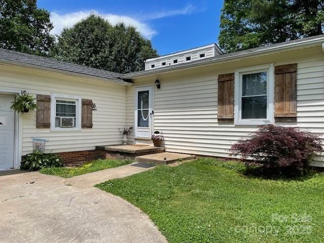 property entrance featuring a garage and a yard