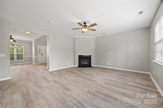 unfurnished living room with a ceiling fan and light wood-type flooring