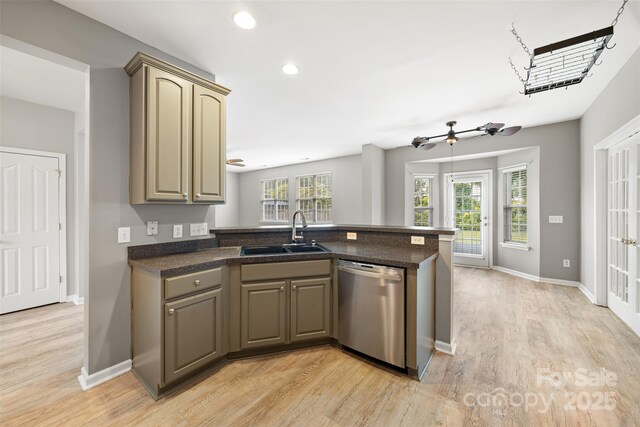 kitchen with a sink, dishwasher, a peninsula, light wood-style flooring, and recessed lighting