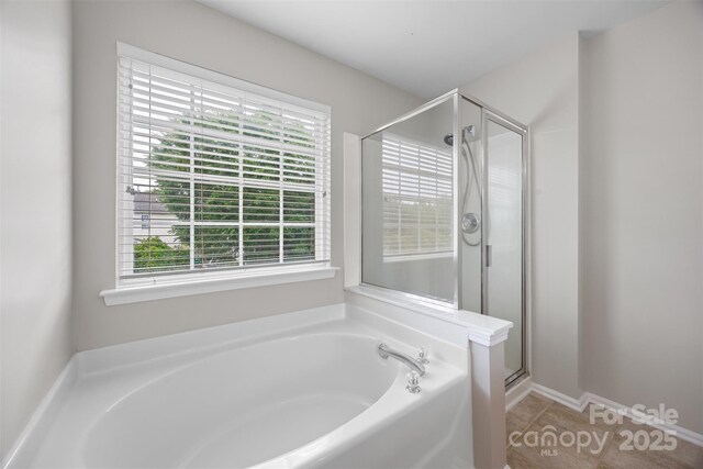 full bathroom with a bath, a shower stall, and tile patterned flooring
