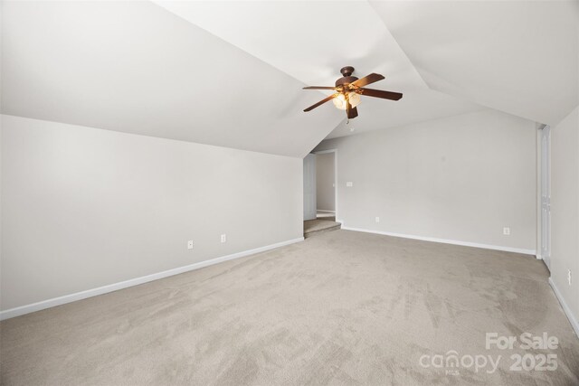 additional living space with vaulted ceiling, a ceiling fan, carpet flooring, and baseboards