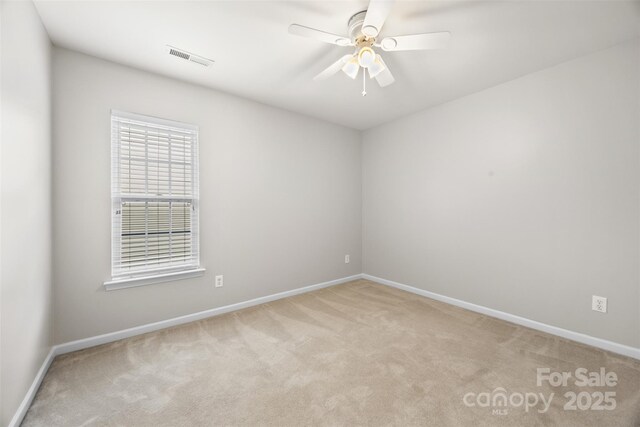 empty room featuring light carpet, baseboards, and ceiling fan