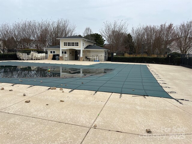 community pool with fence and a patio area
