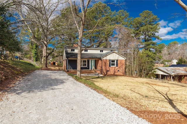 view of front facade with crawl space and gravel driveway