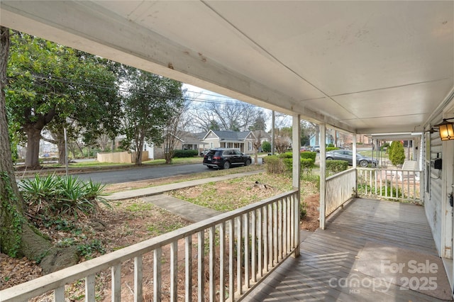 wooden terrace with a residential view and covered porch