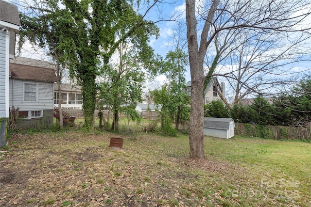 view of yard with a storage unit, an outbuilding, and fence
