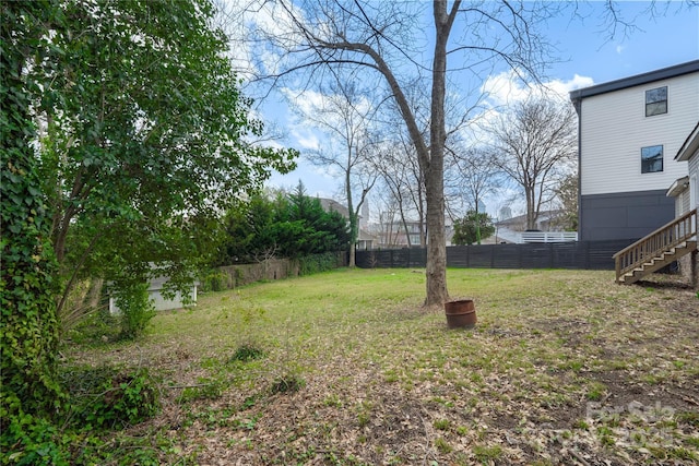 view of yard featuring stairs and fence