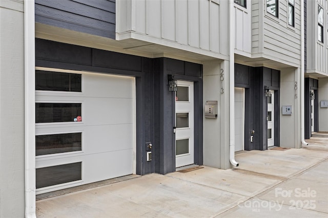 view of exterior entry featuring a garage and board and batten siding