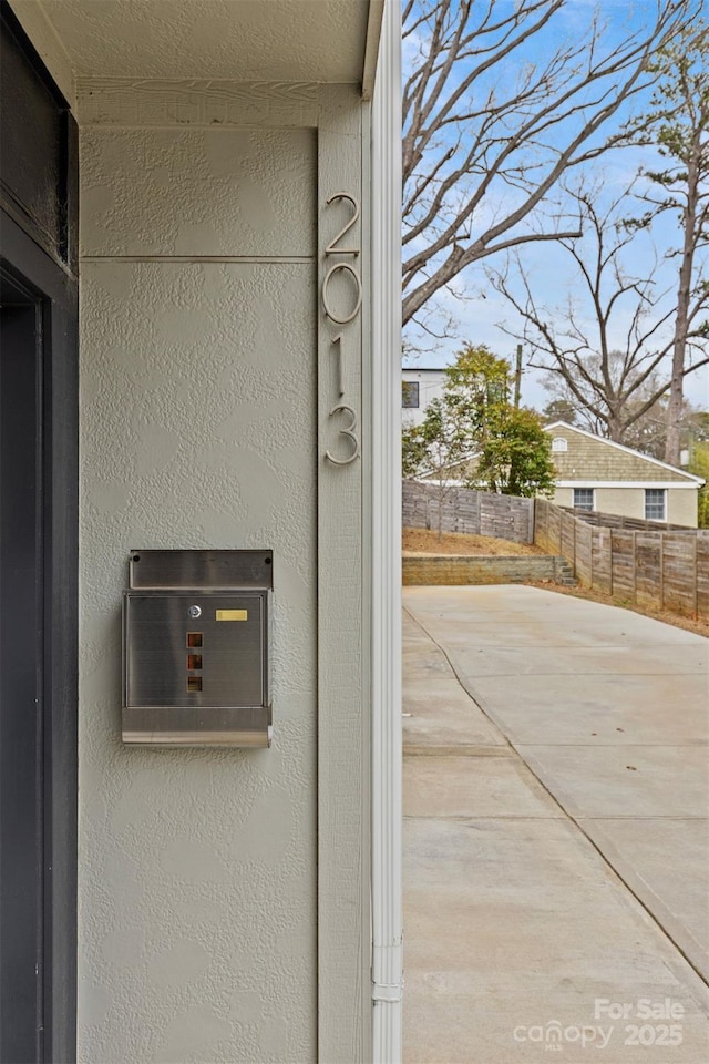 details featuring fence and stucco siding