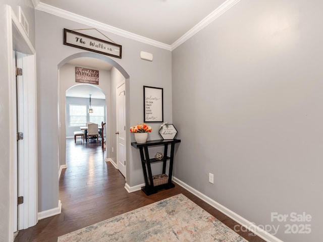 corridor featuring baseboards, visible vents, arched walkways, dark wood-style floors, and crown molding