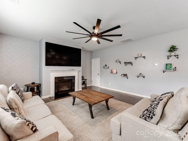 living area with wallpapered walls, wood finished floors, and baseboards