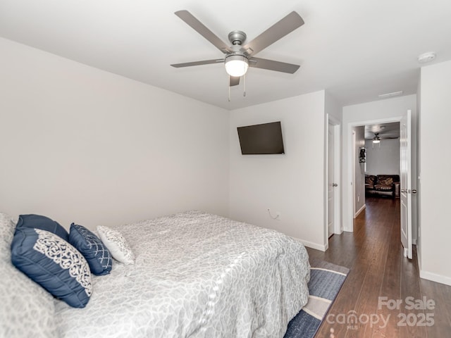 bedroom featuring ceiling fan, baseboards, and wood finished floors