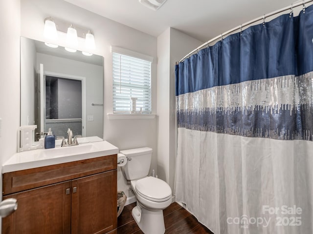 bathroom with toilet, visible vents, wood finished floors, and vanity