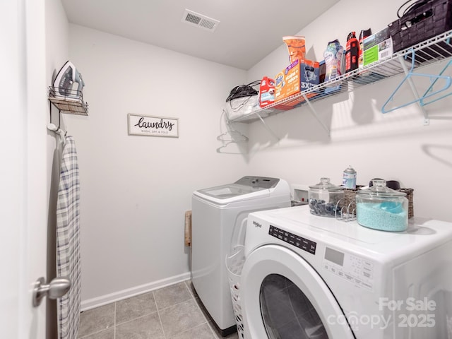 laundry room featuring laundry area, light tile patterned floors, visible vents, baseboards, and washing machine and dryer