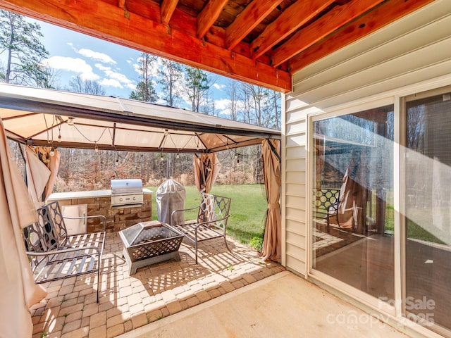 view of patio featuring a fire pit, grilling area, and a gazebo