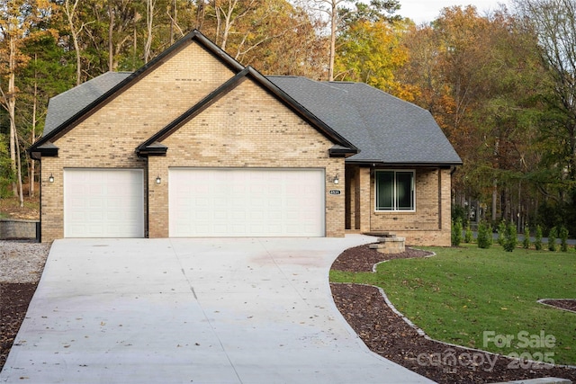 view of front facade featuring a garage, a front yard, concrete driveway, and roof with shingles