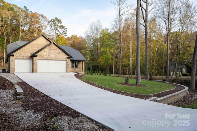 view of front of home featuring a garage, a front lawn, concrete driveway, and brick siding