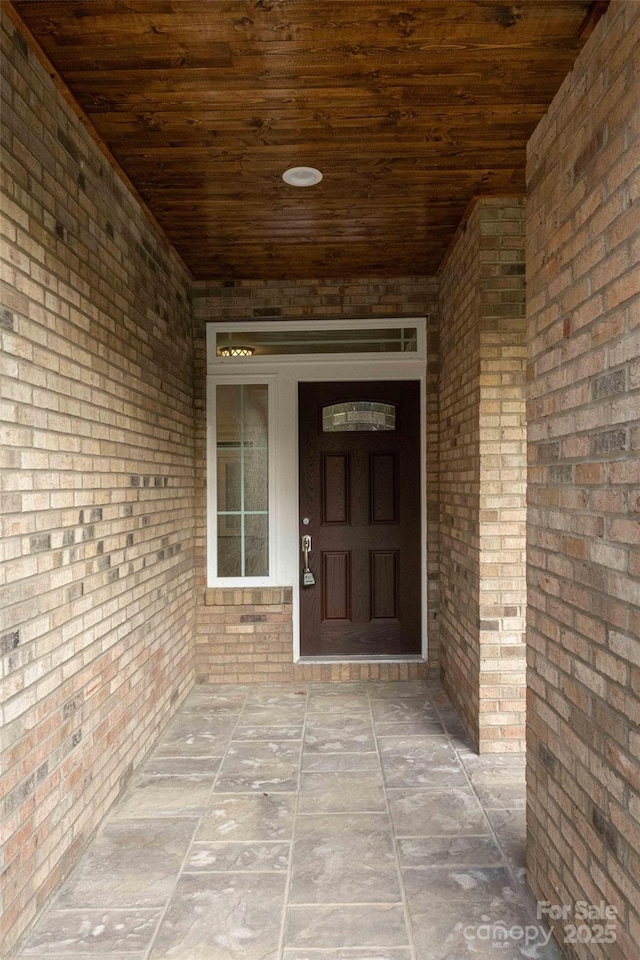 view of exterior entry featuring brick siding