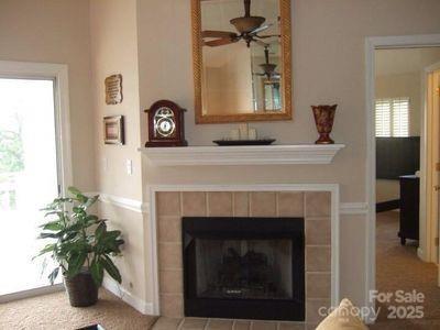 interior details with ceiling fan, carpet floors, and a tile fireplace