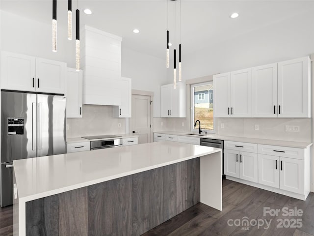 kitchen featuring high end fridge, white cabinetry, and a sink