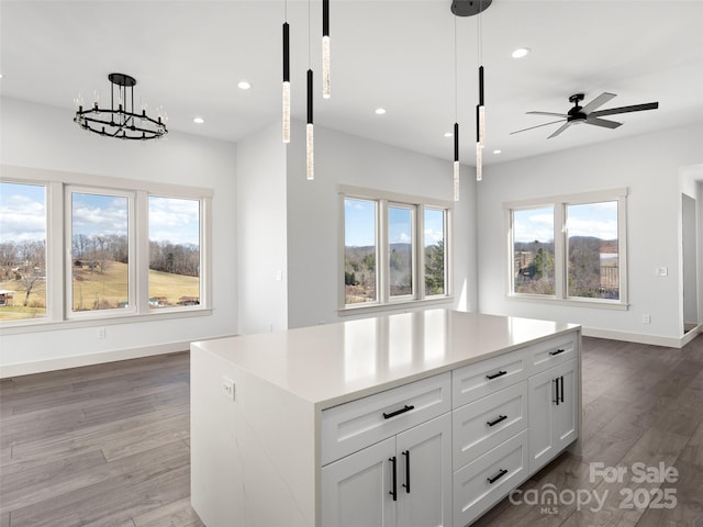 kitchen featuring plenty of natural light, light wood-style flooring, and decorative light fixtures