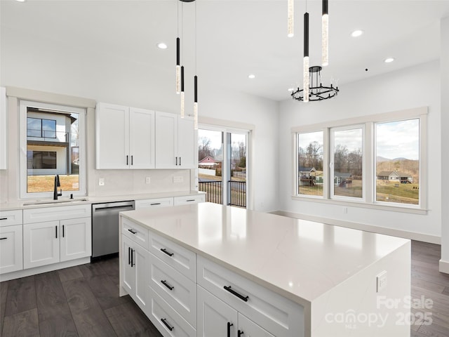 kitchen featuring dishwasher, a sink, dark wood finished floors, and white cabinets