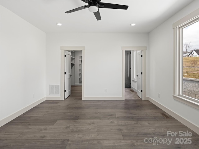 unfurnished bedroom featuring dark wood-type flooring, visible vents, and baseboards