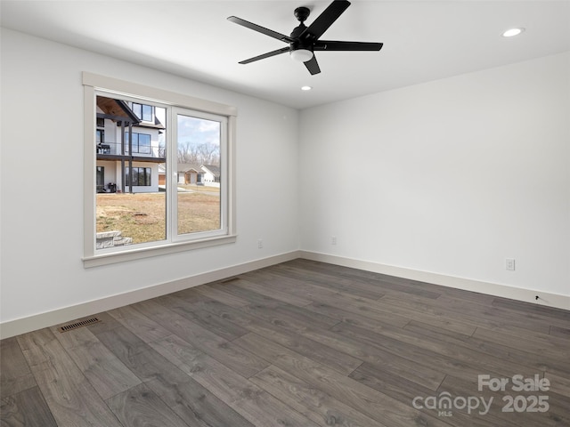 spare room featuring recessed lighting, dark wood-style flooring, visible vents, and baseboards