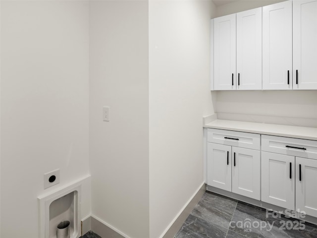 laundry room featuring baseboards, cabinet space, and electric dryer hookup