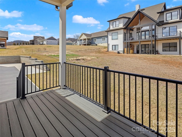 wooden deck featuring a lawn and a residential view