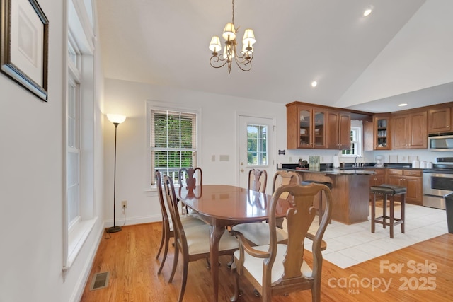 dining room with a chandelier, light wood-style flooring, recessed lighting, visible vents, and vaulted ceiling