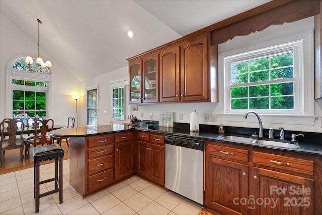 kitchen with lofted ceiling, a peninsula, a sink, stainless steel dishwasher, and dark countertops