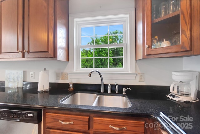 kitchen with a sink, stainless steel dishwasher, brown cabinets, dark stone counters, and glass insert cabinets