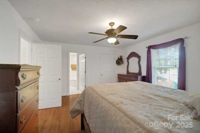 bedroom featuring a textured ceiling, a ceiling fan, wood finished floors, and ensuite bathroom