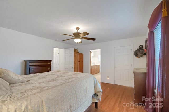 bedroom featuring connected bathroom, ceiling fan, a textured ceiling, and wood finished floors