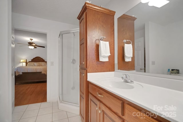 bathroom with tile patterned flooring, vanity, a textured ceiling, and a shower stall