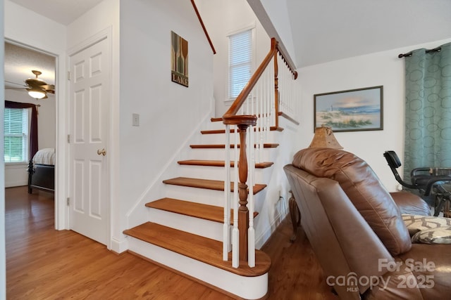 staircase featuring ceiling fan, wood finished floors, and baseboards