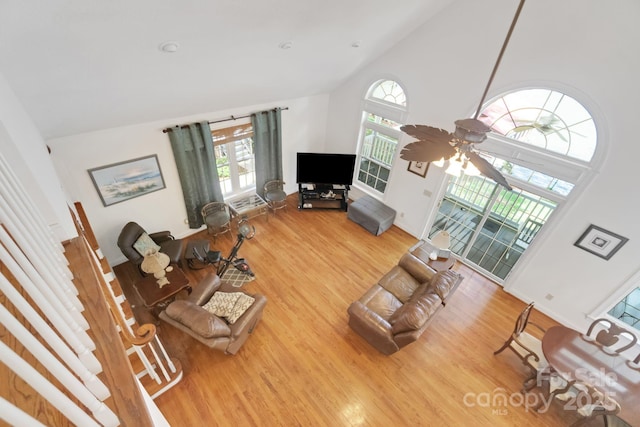 unfurnished living room featuring high vaulted ceiling, a ceiling fan, and wood finished floors