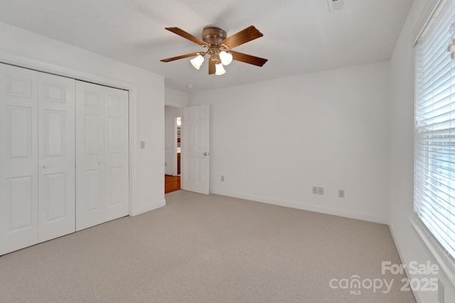 unfurnished bedroom featuring a ceiling fan, a closet, carpet flooring, and baseboards