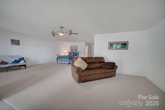 living area featuring carpet floors, a ceiling fan, and a textured ceiling