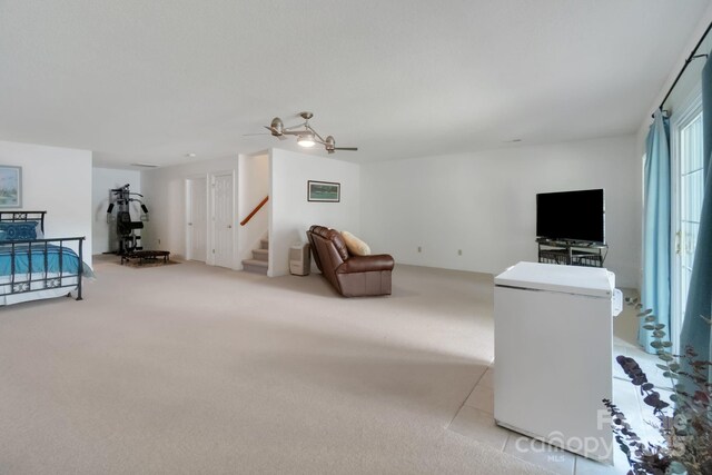 living area with stairs and light carpet