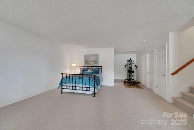 living area with carpet flooring, a textured ceiling, baseboards, and stairs