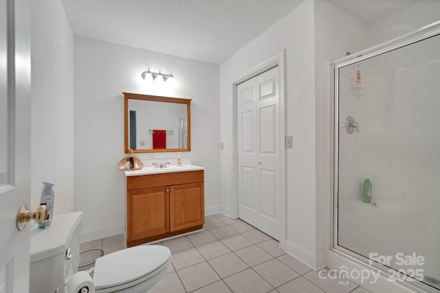 bathroom featuring a textured ceiling, vanity, a shower stall, and toilet