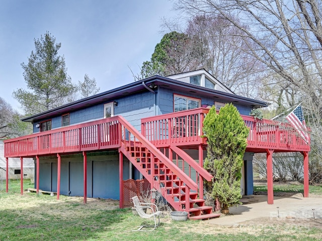 rear view of house featuring a lawn, a deck, and stairs