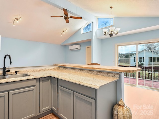 kitchen featuring a sink, gray cabinets, and a wall unit AC