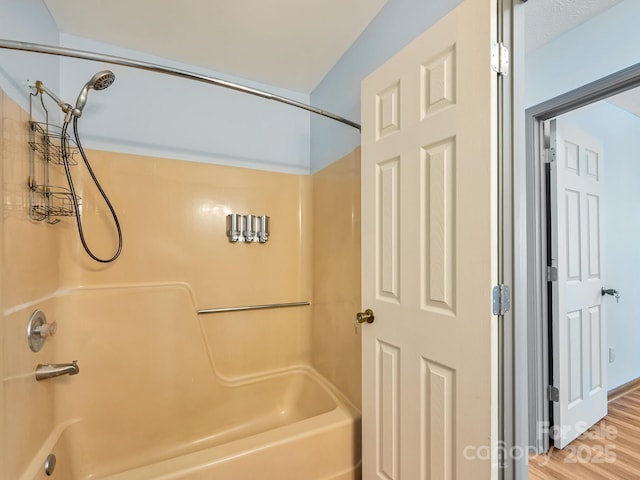 bathroom featuring  shower combination and wood finished floors