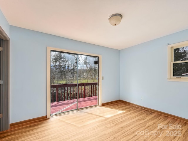 unfurnished room with baseboards and wood finished floors