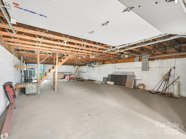 basement featuring stairway, electric panel, and water heater