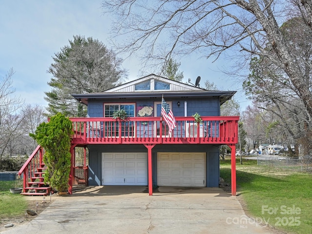 view of front of house featuring an attached garage, stairs, driveway, and a front lawn